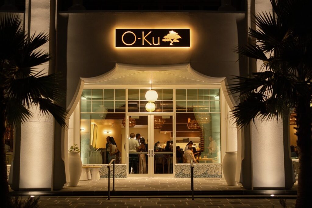 O-Ku sushi restaurant entrance lit up at night in Alys Beach, Florida