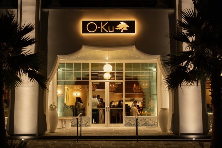 O-Ku sushi restaurant entrance lit up at night in Alys Beach, Florida
